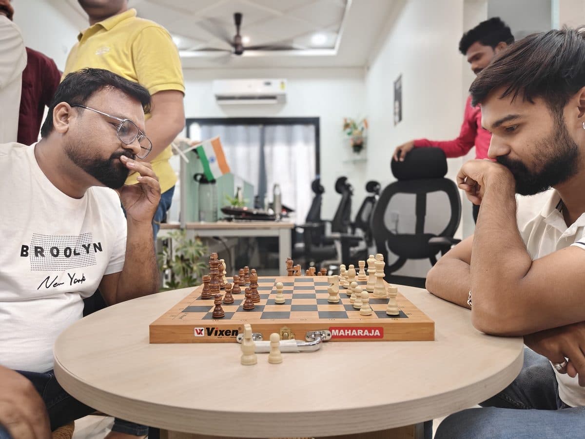 Koderz teammates playing chess at the office